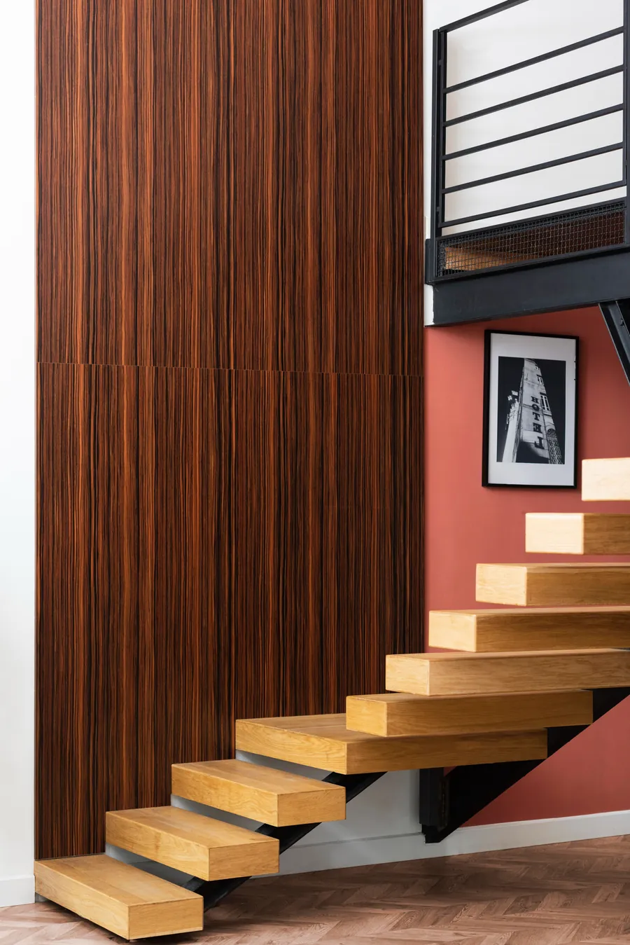 Floating staircase beside a wood-panelled wall